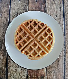 A Belgium waffle sitting on a plate.