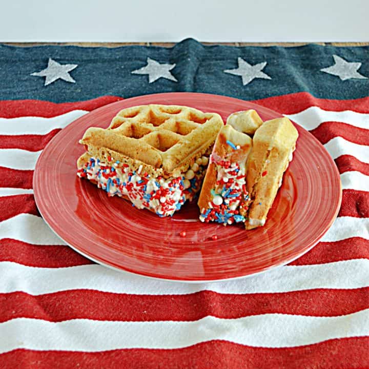 A plate with two waffle ice cream sandwiches rolled in red, white, and blue sprinkles.