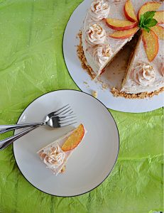 A top view of a slice of Brown sugar cake with peach jam filling with two forks on the plate and a top view of the whole cake with a slice cut out of it.