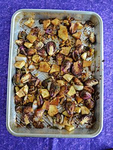 A sheet pan with Brussels Sprouts and Sweet Potatoes.
