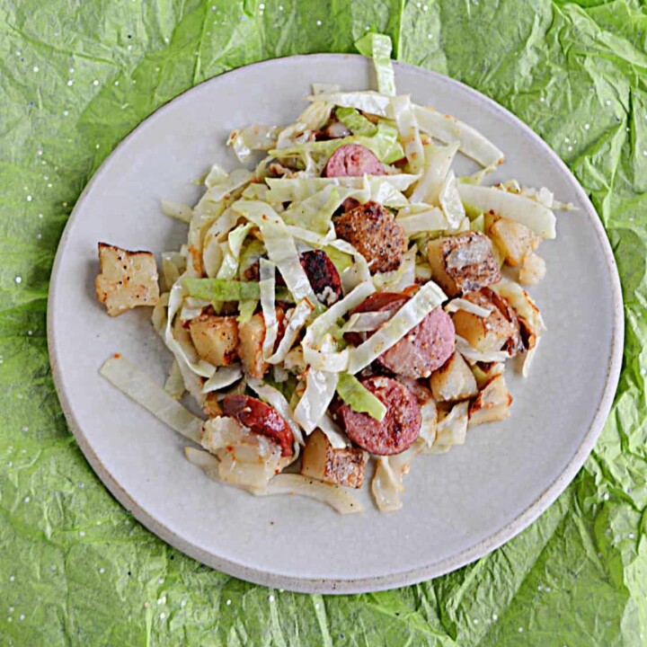 A plate piled with cabbage, kielbasa, and potatoes.