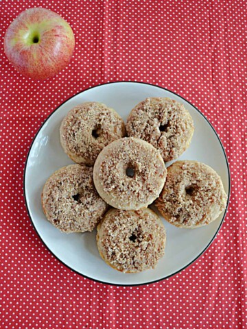 A plate topped piled high with Apple Cider Donuts rolled in pecan sugar.