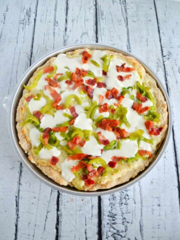 A close up view of a Hatch Chile Pizza topped with Mozzarella, bacon,a nd roasted Hatch Chiles.