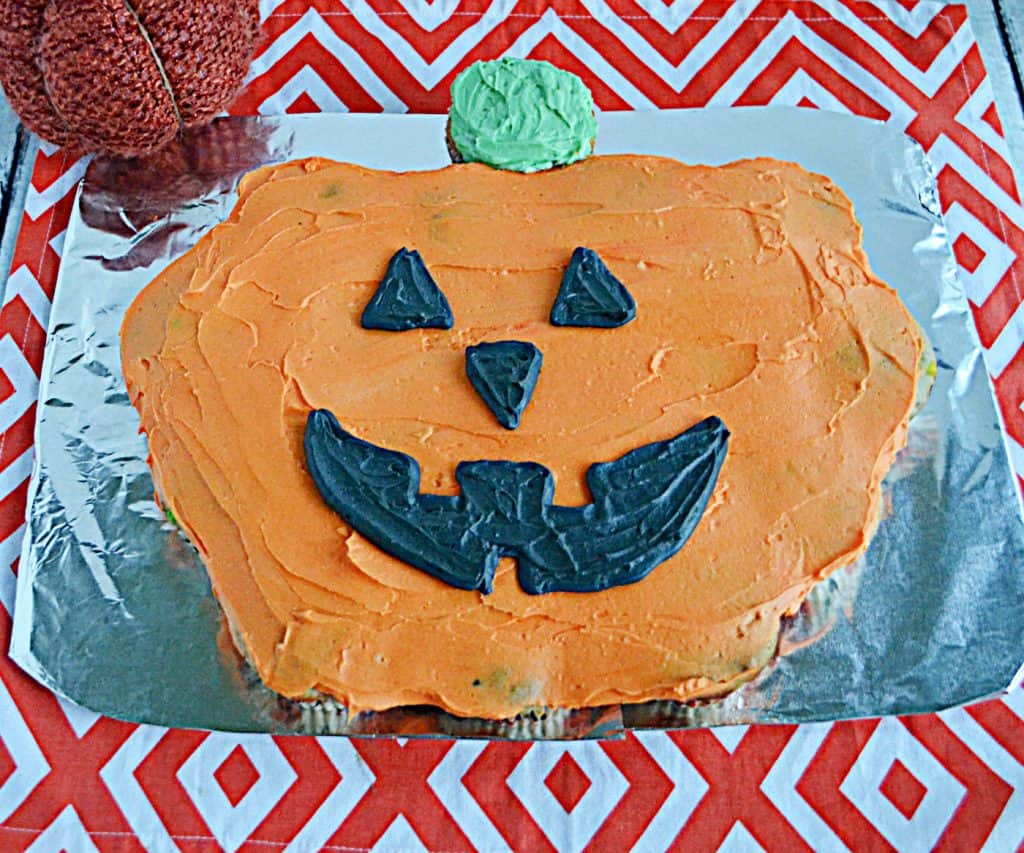 A large pull apart Pumpkin Cupcakes with black jack-o-lantern face.