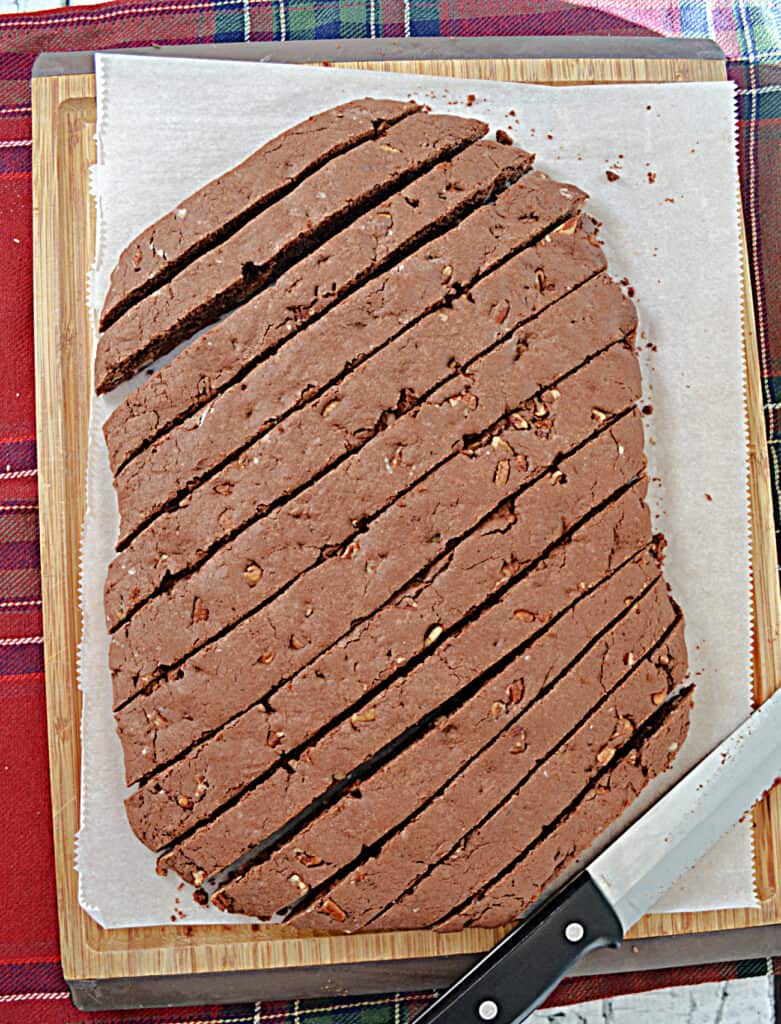 Chocolate Biscotti cut into slices on a diagonal with a knife at the bottom