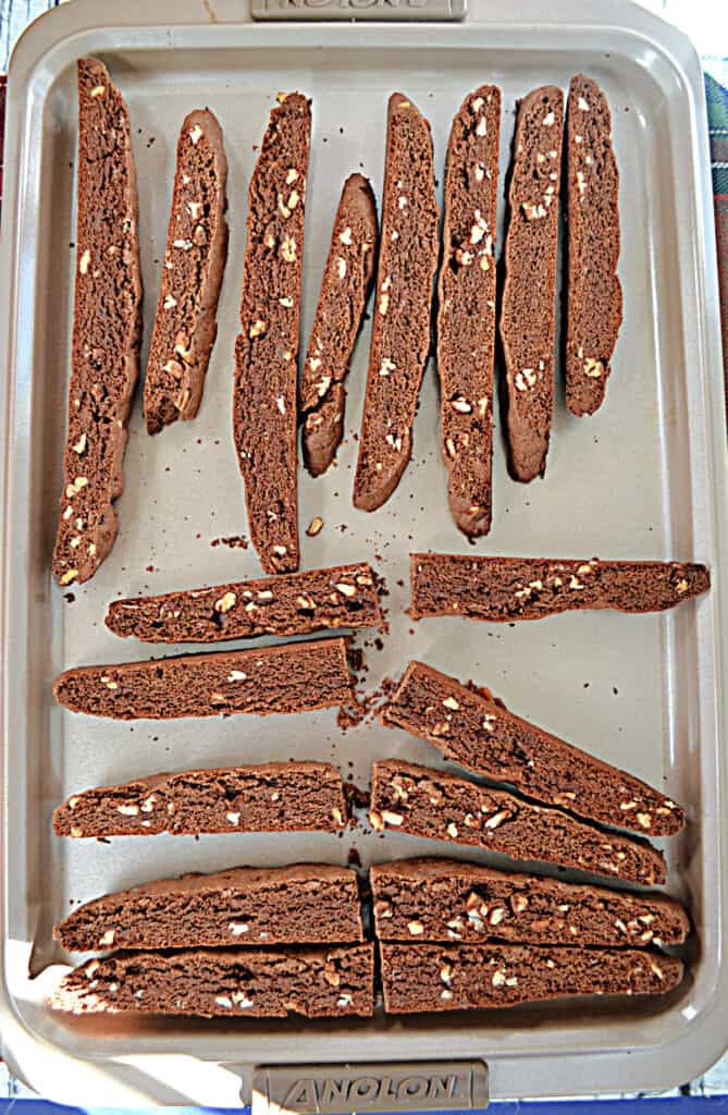 Pieces of chocolate pecan biscotti laying on a cookie sheet.