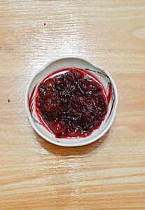 A small bowl filled with chunky cranberry sauce.