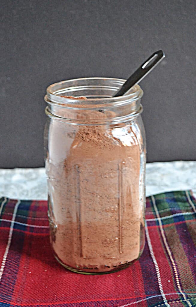 A jar of hot chocolate mix with a spoon in it.