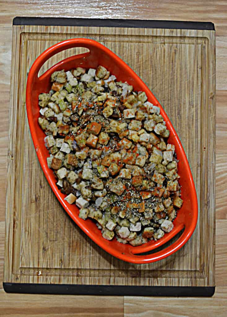 An orange baking dish overflowing with stuffing.