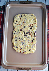A sheet pan with biscotti cookie dough shaped into a rectangle.