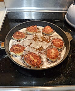 A pan with Tuna Croquettes frying in it.