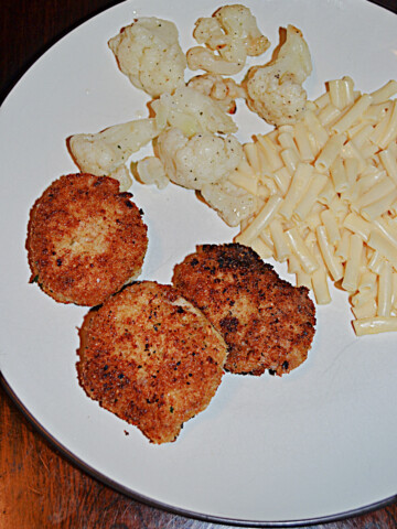 A plate with 3 Tuna Croquettes, a scoop of mac n cheese, and cauliflower.