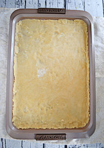 A jelly roll pan with homemade crust for a pie.