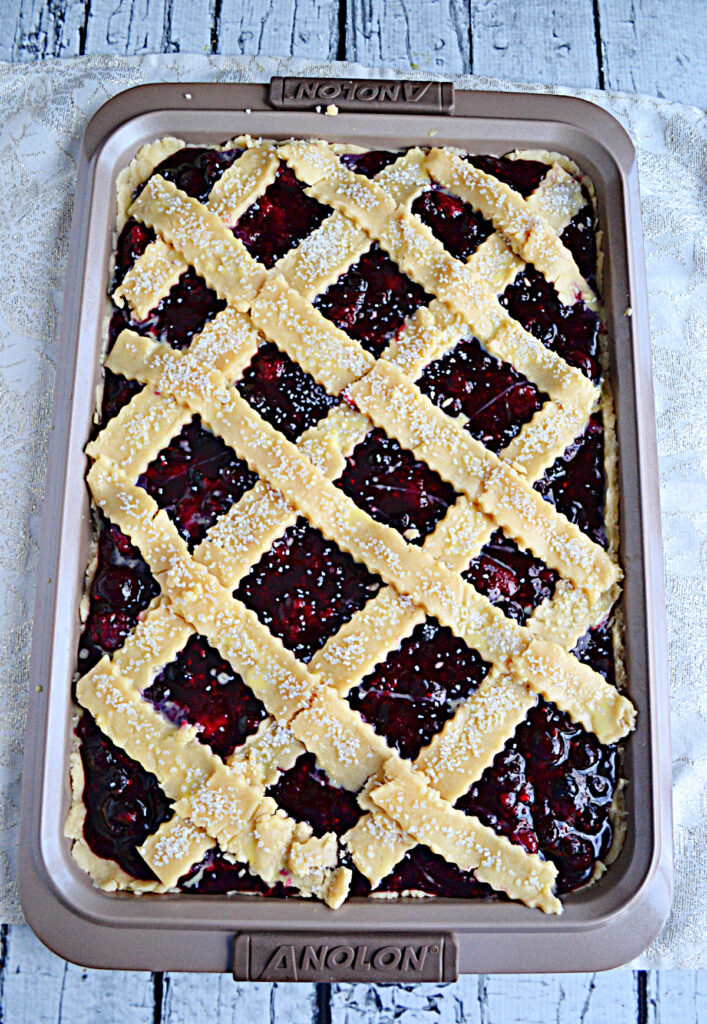 A jelly roll pan with a berry slab pie with lattice top.