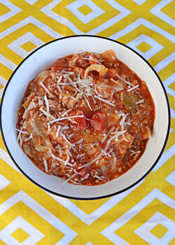 A bowl of stuffed cabbage soup with cheese on top.