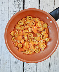 A skillet with sliced kumquats in it.