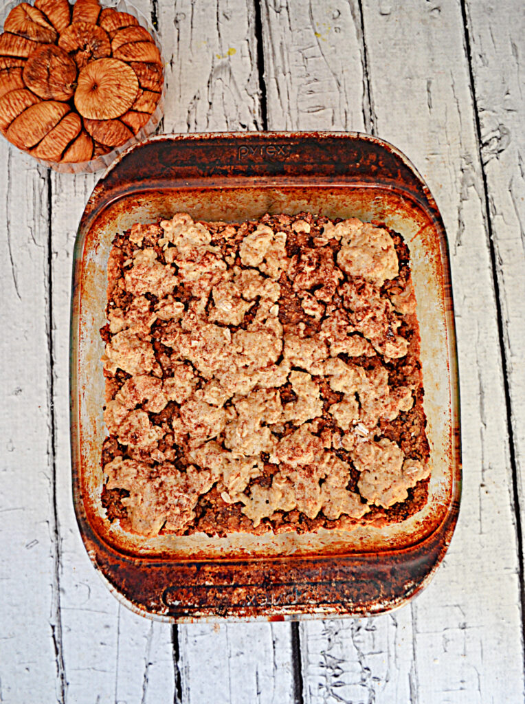 A baking dish with fig crumble bars and a bowl of figs. 