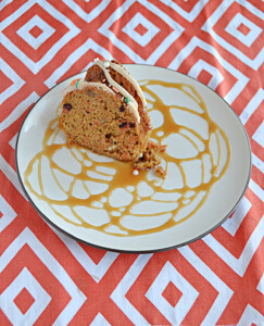 A plate drizzled with caramel with a slice of Carrot Coffee Cake on it.