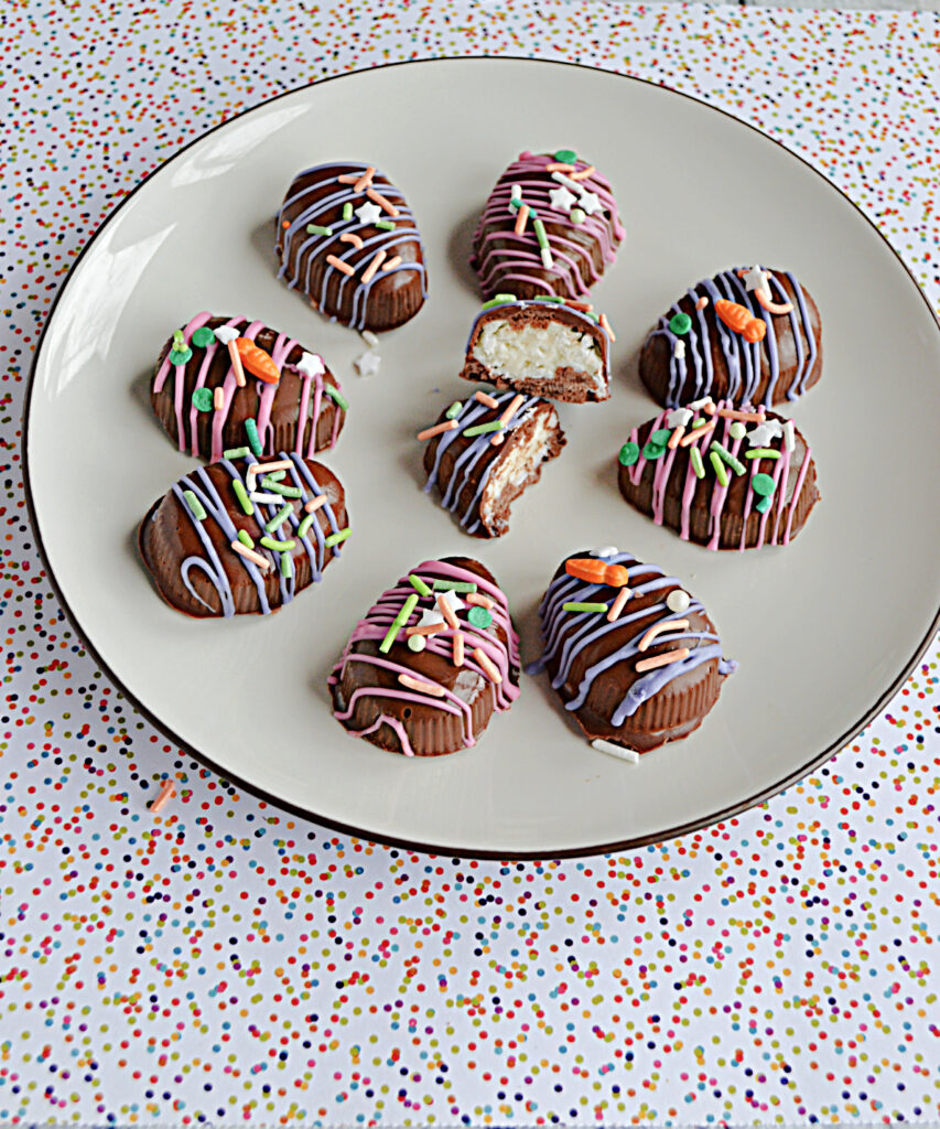 A plate with chocolate coconut Easter eggs on it drizzle in pink and purple chocolate and colored sprinkles and one egg broken open in the middle to show the coconut inside.