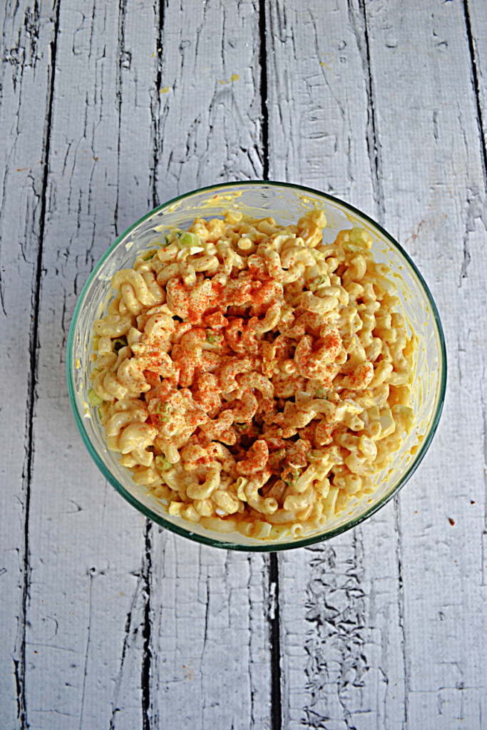 A bowl of Deviled Egg Macaoni Salad with paprika on top. 