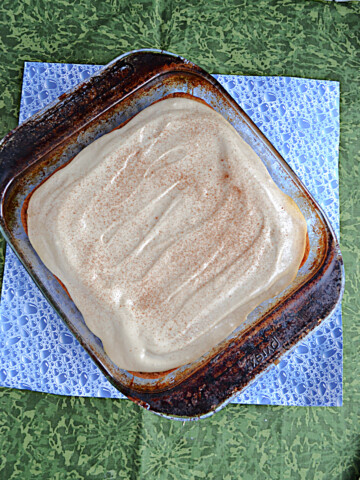 A baking dish with coffee cake and cream cheese frosting.