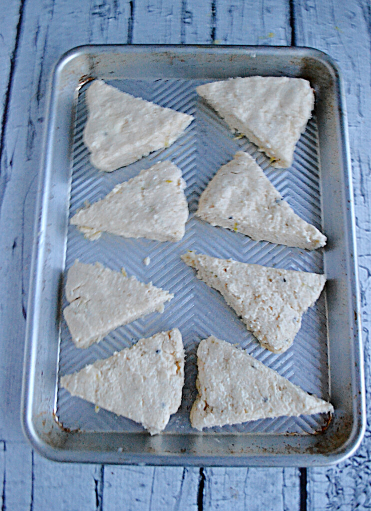 A baking sheet with 8 scones ready to be cooked. 