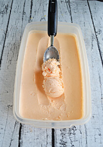 A container of Thai Tea Ice cream with a large scoop at the end of the ice cream scoop.