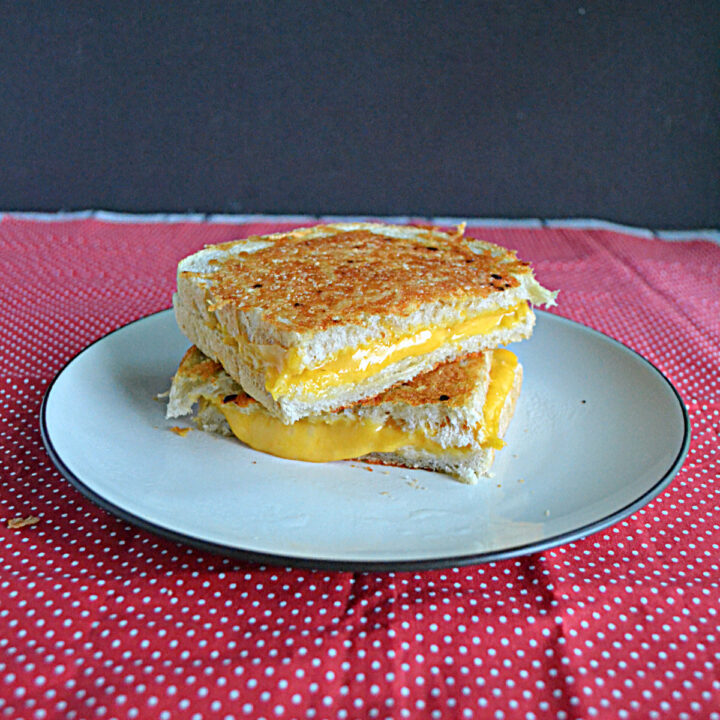 Front view of a grilled cheese, cut in half, on a plate, and stacked.
