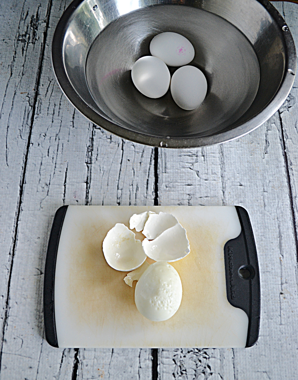 A bowl of hard boiled eggs and one egg with the shell taken off. 