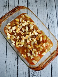 A baking dish filled with apples and caramel sauce.