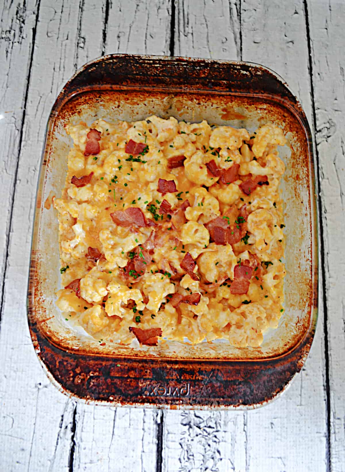 A baking dish with cauliflower casserole topped with bacon.