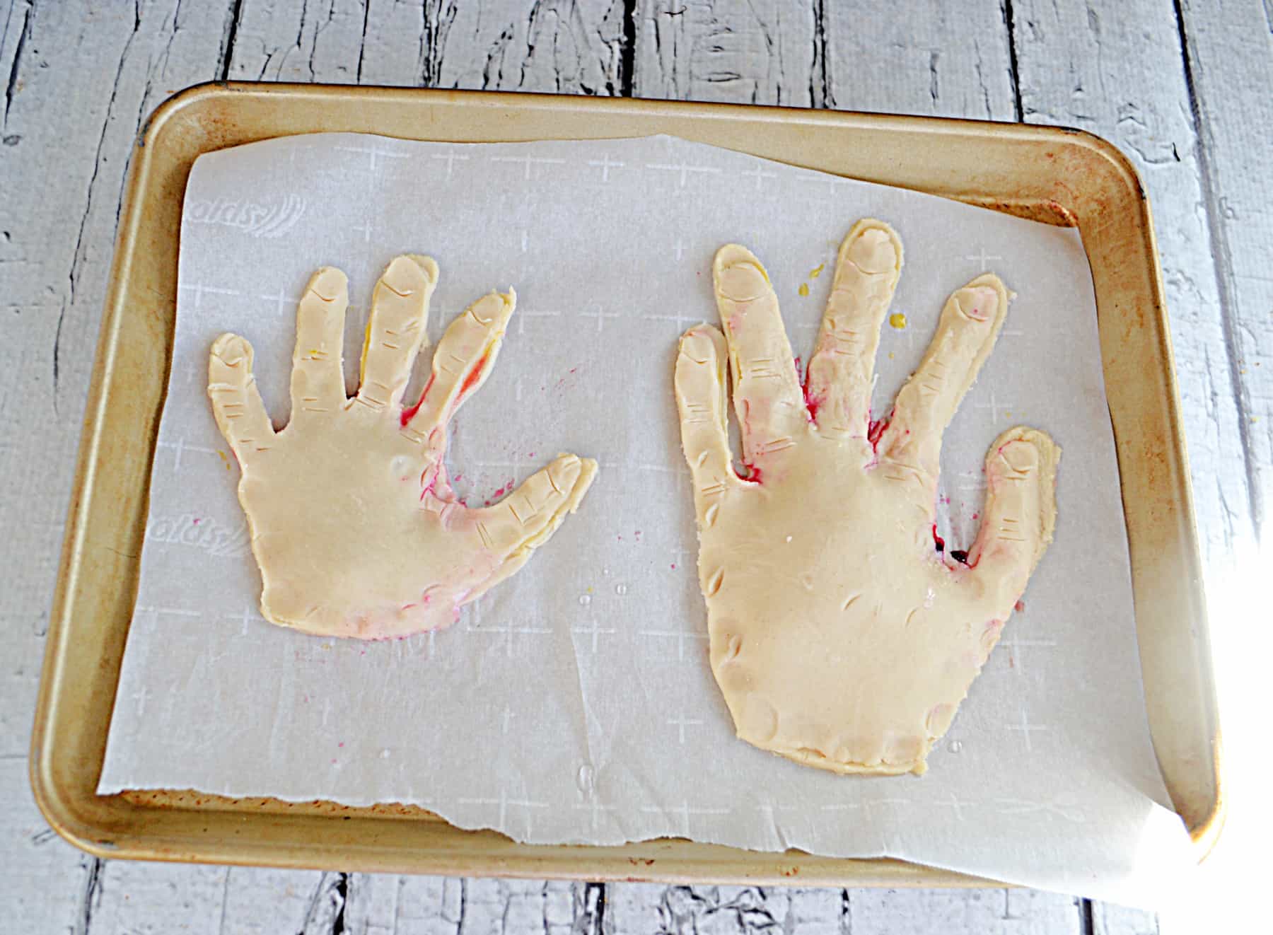 Hand prints cut from pie crust and filled with homemade jam. 