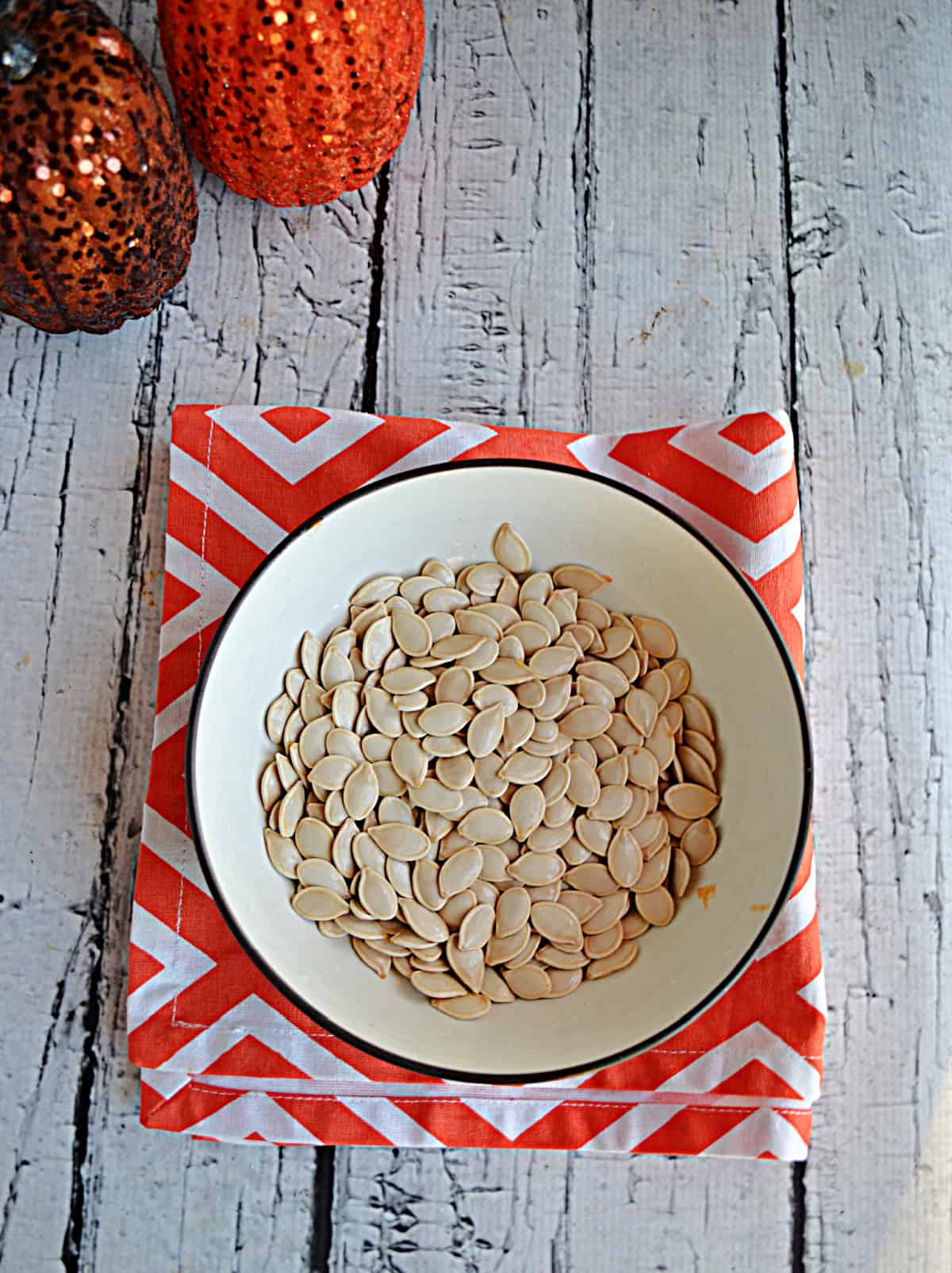 A bowl of raw pumpkin seeds. 