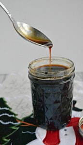 A jar of Gingerbread Syrup with a spoon taking some out.