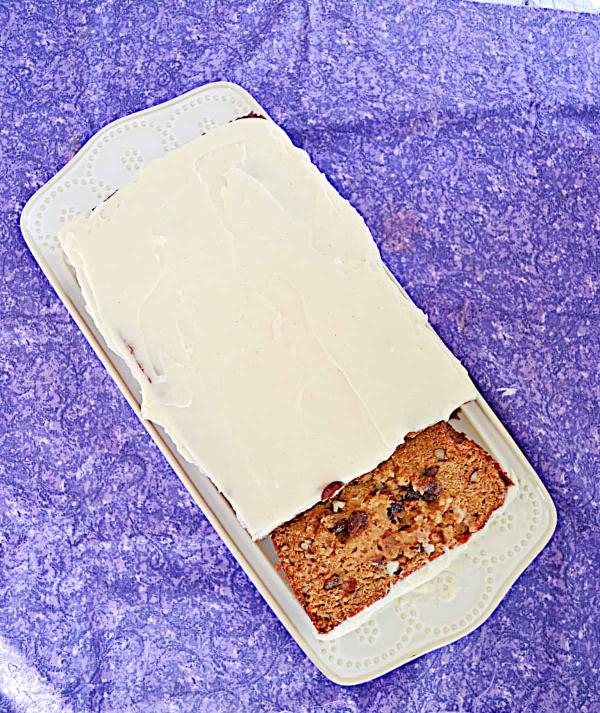 A loaf of persimmon bread frosted with cream cheese frosting.
