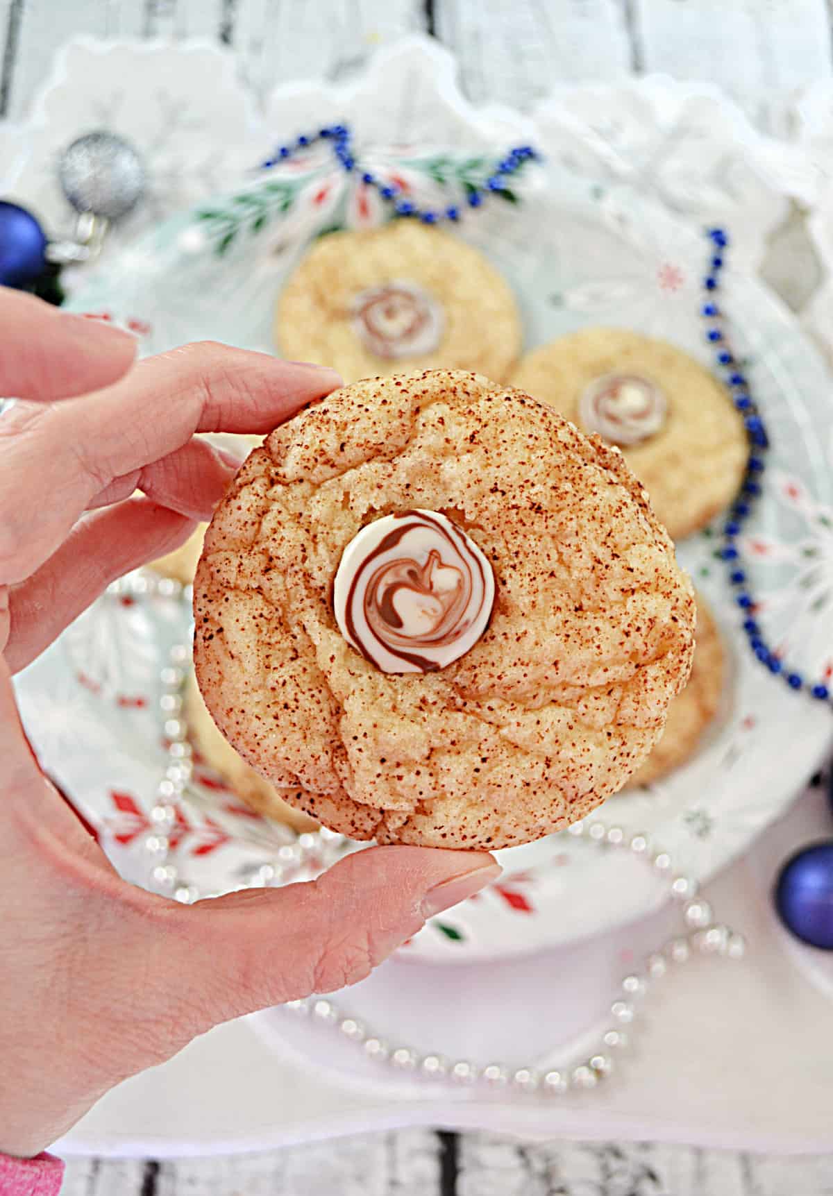 A hand holding a Cappuccino Cookie with a chocolate center.