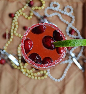 A top view of a glass of cranberry champagne cocktail with fresh cranberries in it.