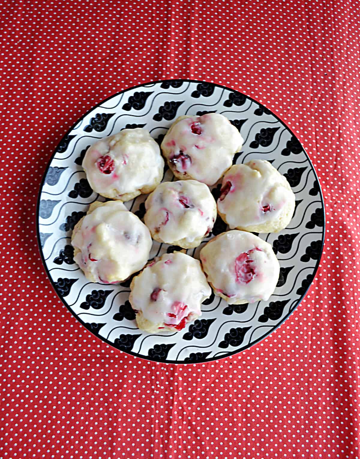 A plate with seven Lemon Cranberry Cookies on it. 
