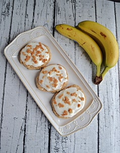 A platter of Banana Bread Cookies with a bunch of bananas behind it.