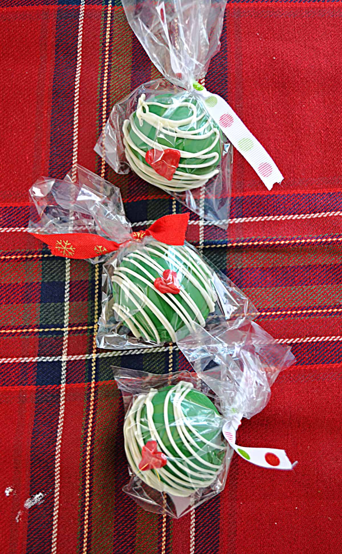 Three wrapped Grinch Hot Cocoa Bombs