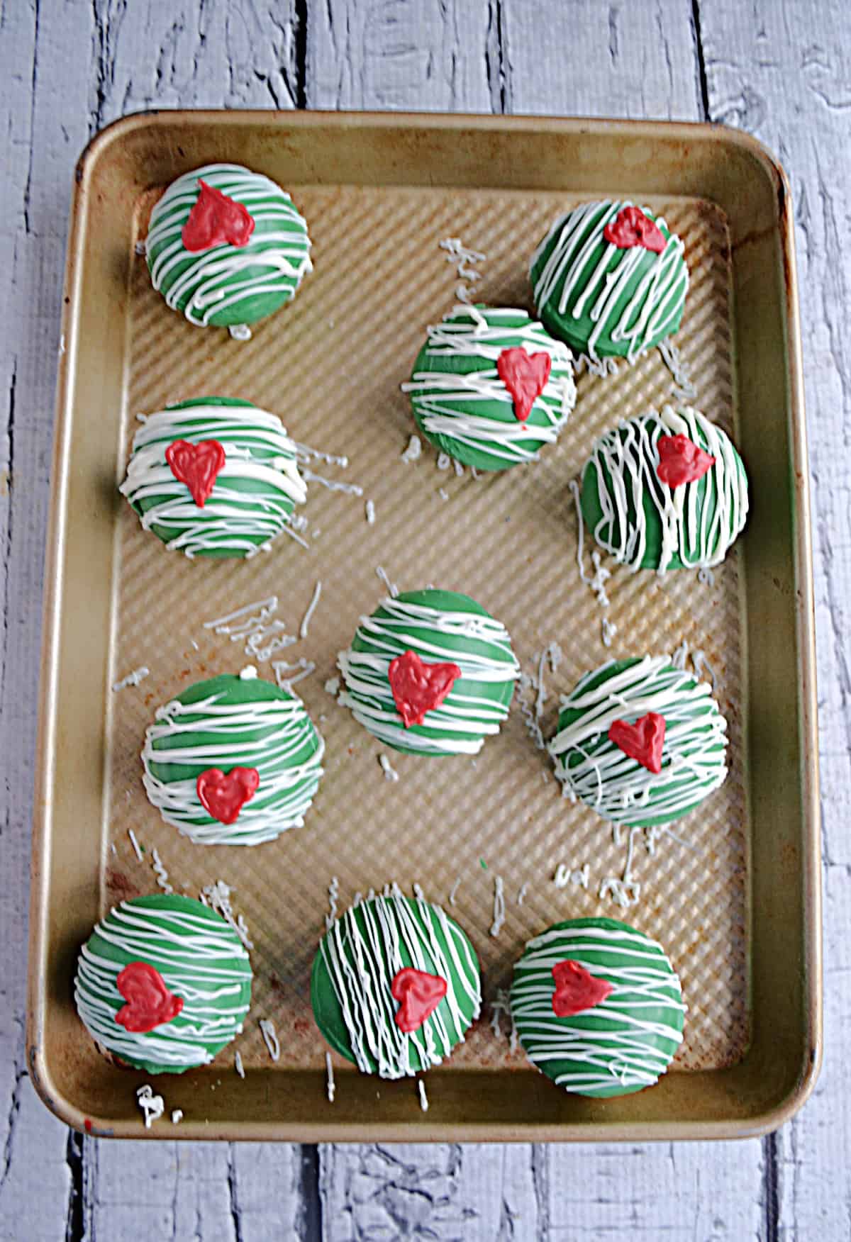 A tray of Grinch Hot Cocoa Bombs with a heart on the front.