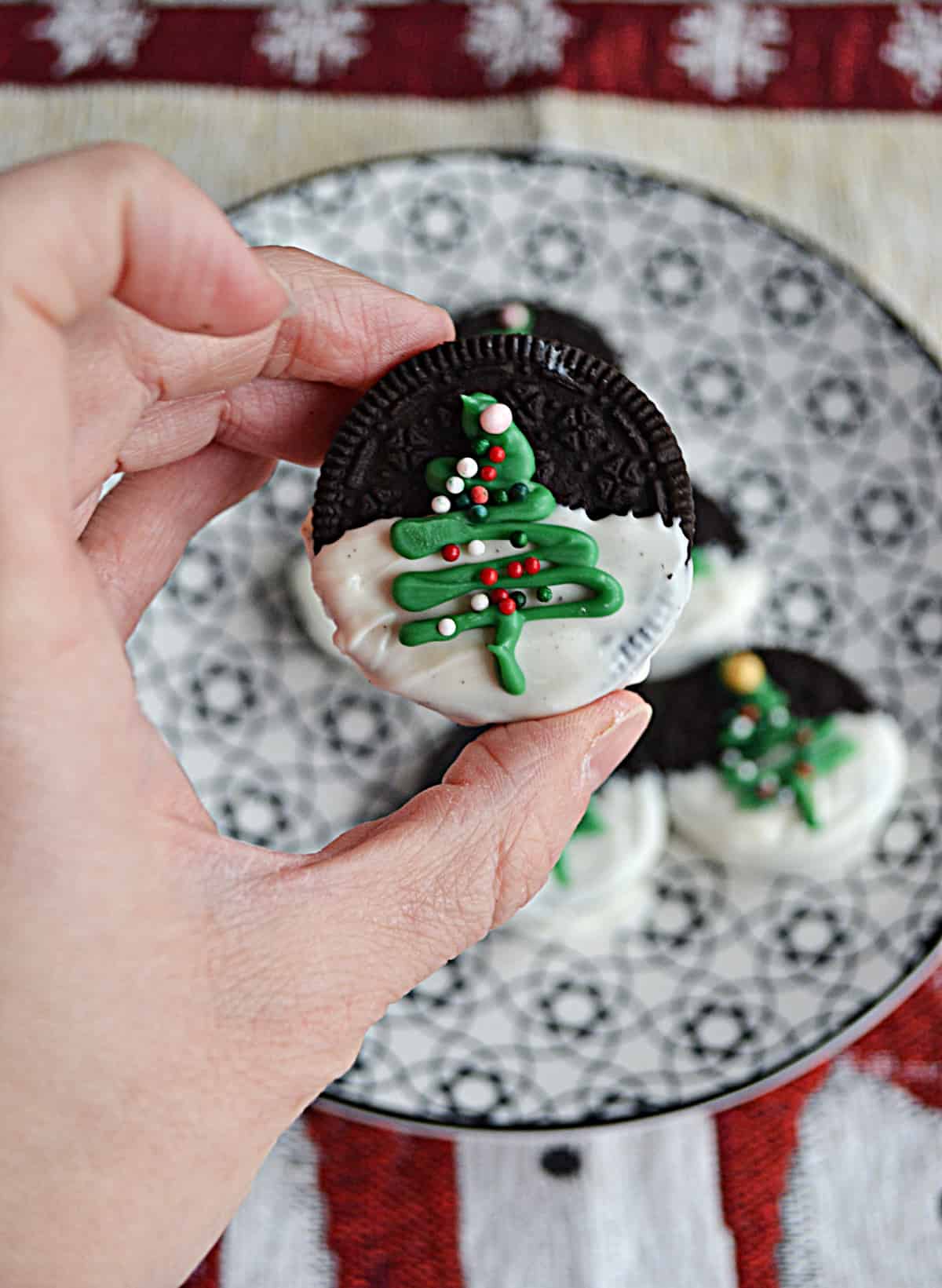 A close up of an Oreo with a Christmas tree on it.