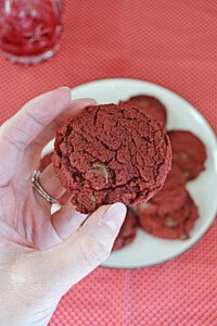 A hand holding a red velvet cookie.