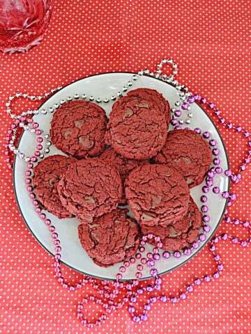 A plate of vegan red velvet cookies with beads on the plates.