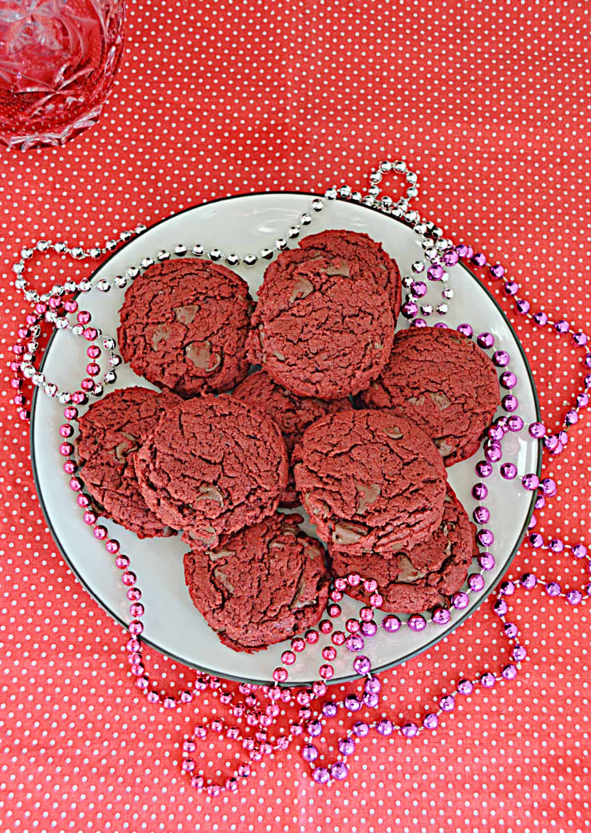 A plate of vegan red velvet cookies with beads on the plates. 