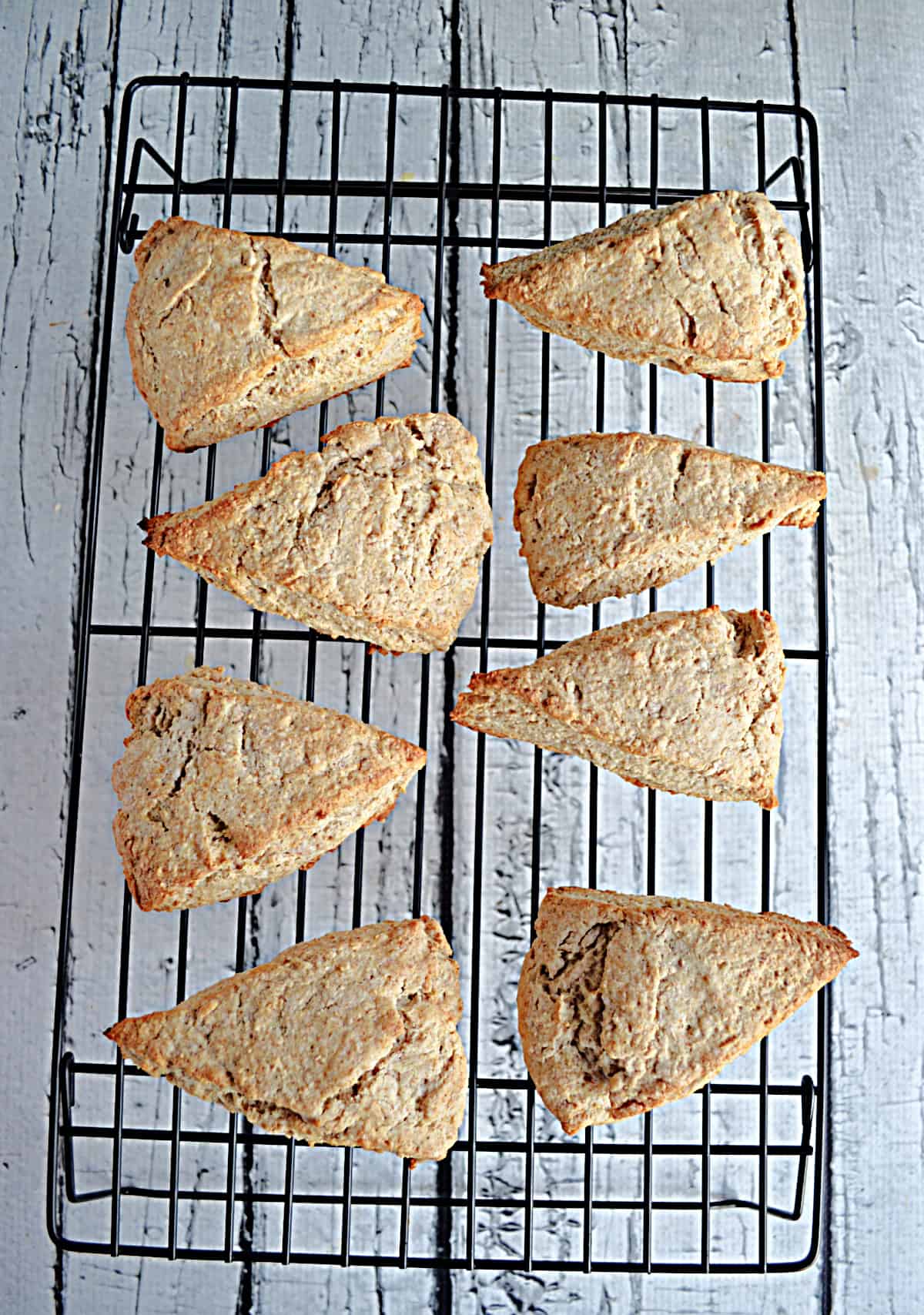 A cooling rack with 8 scones on it. 