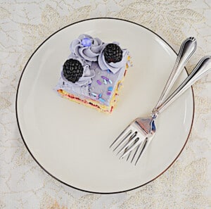 A top view of a slice of cake on a plate with two forks.