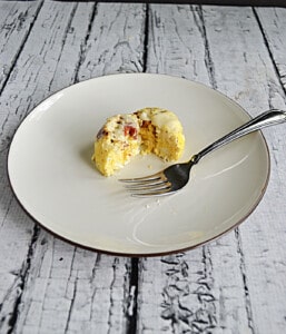 A plate with an egg bite cut in half on it.