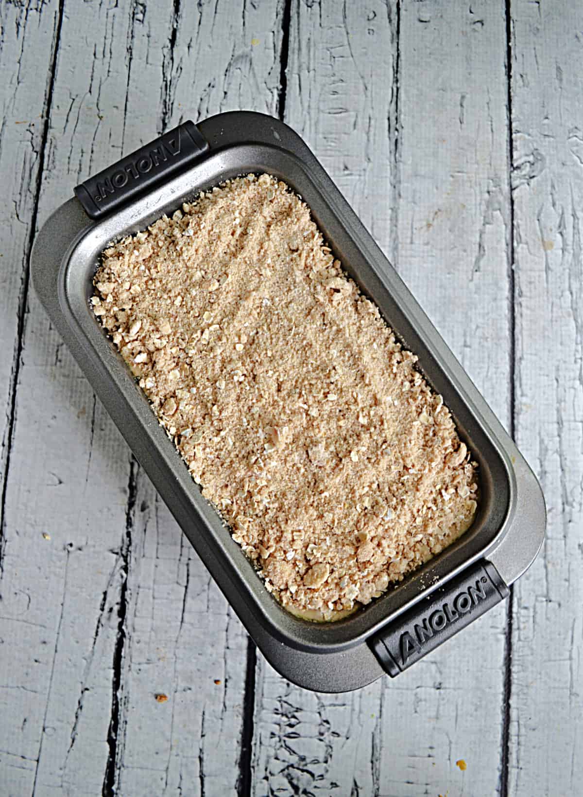A loaf pan with cherry bread and crumble topping. 