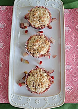 A platter with three rhubarb muffins on it.